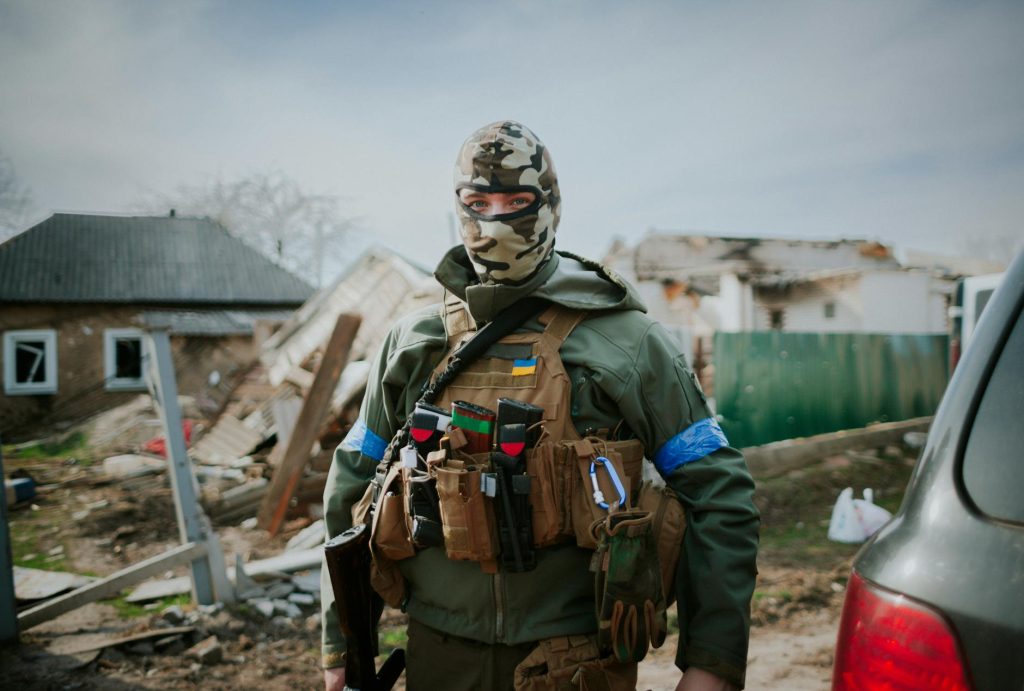 a person in green jacket wearing camouflage mask